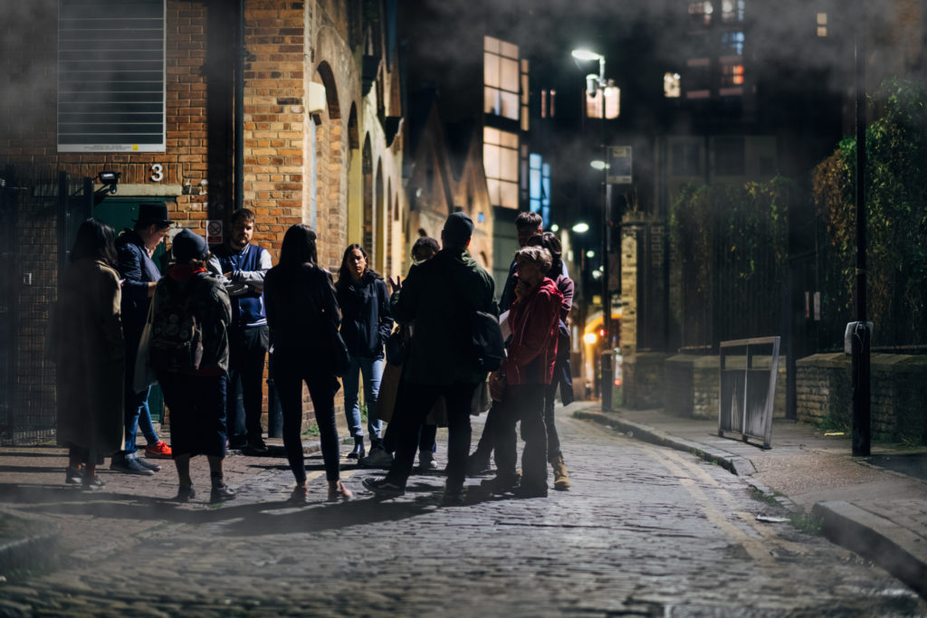 Group of people on a Jack the Ripper tour standing at a corner